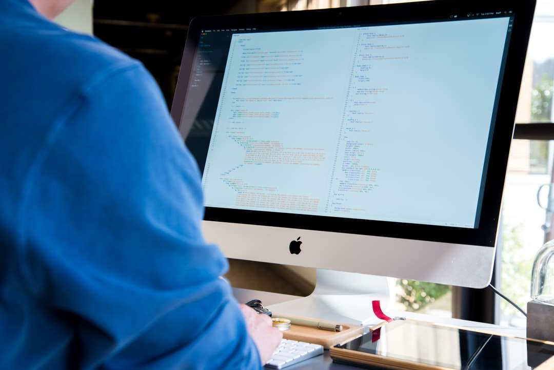човек, изправен пред монитора, докато пише през деня онлайн пъзел