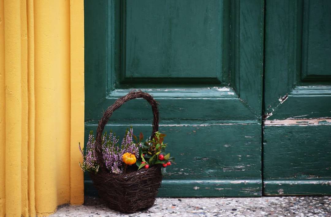 canasta marrón llena de flores cerca de la puerta rompecabezas en línea