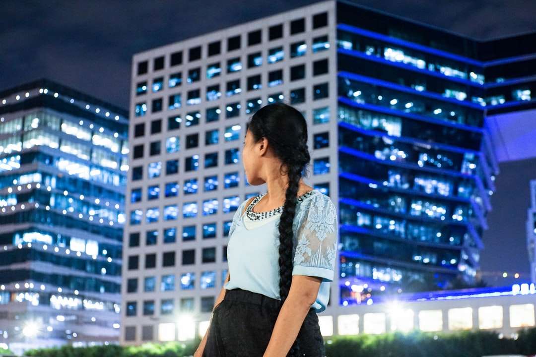 γυναίκα σε άσπρο και μαύρο μπλουζάκι στέκεται κοντά σε κτίριο παζλ online