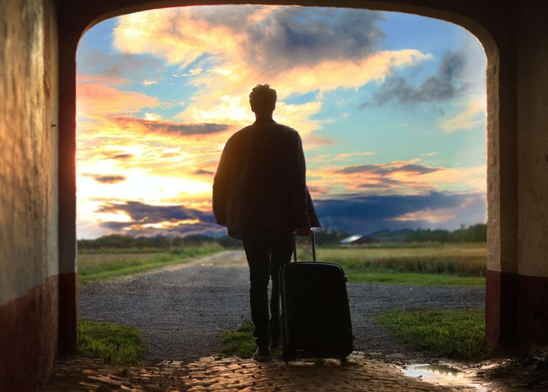 мъж, държащ снимка на багаж онлайн пъзел