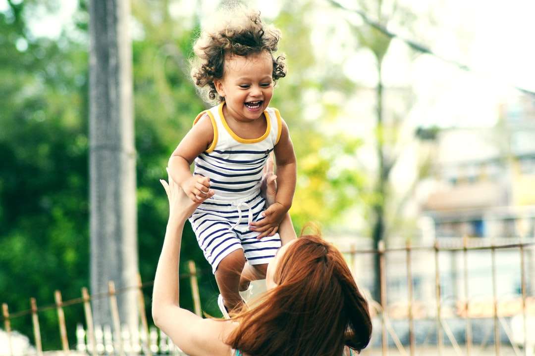 επιλεκτική εστίαση φωτογραφία της γυναίκας που σηκώνει το παιδί κατά τη διάρκεια της ημέρας online παζλ