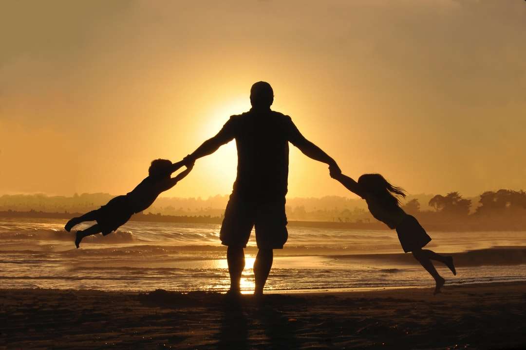 silhouette, de, homme, tenue, deux enfants, sur, rivage puzzle en ligne