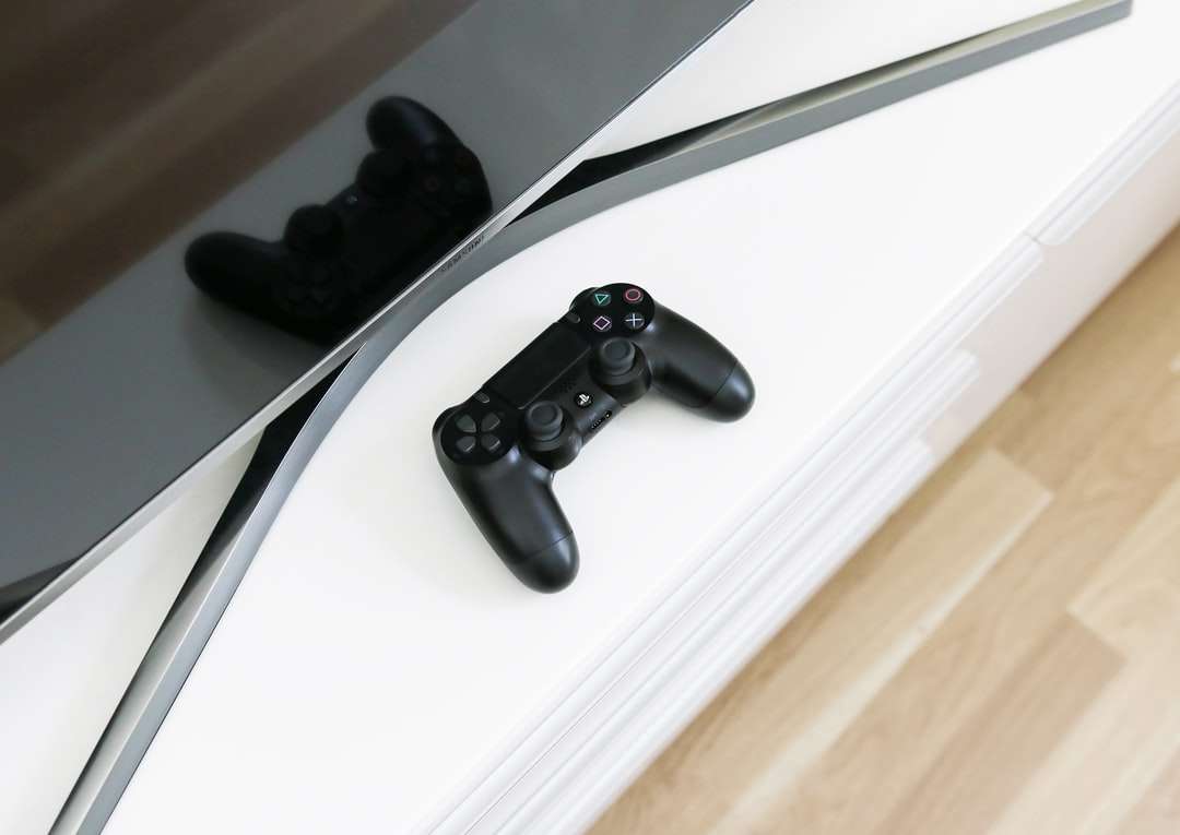 black Sony PS3 controller on white surface online puzzle