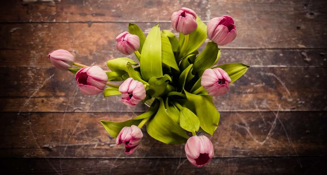 ροζ κεντρικό τεμάχιο λουλουδιών με πέταλα σε καφέ ξύλινη επιφάνεια online παζλ