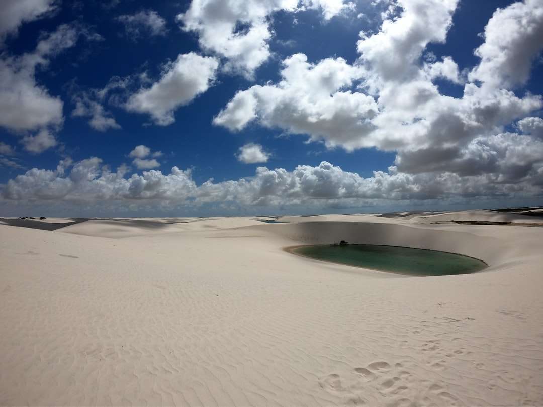 sand dunes with lagoon under cloudy sky online puzzle
