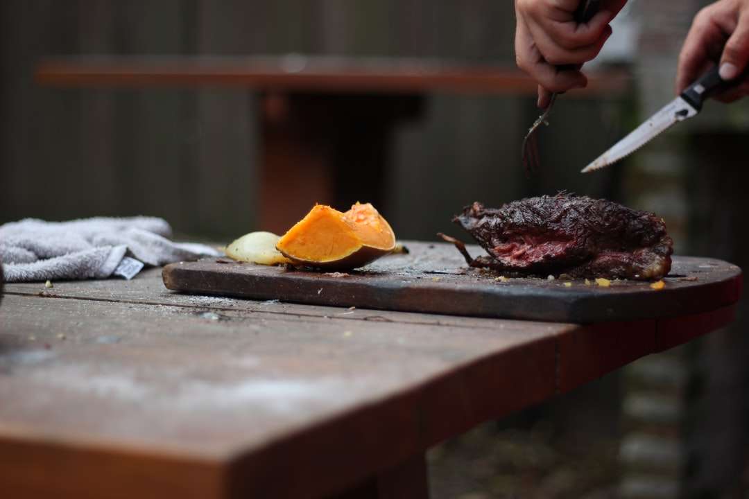 човек, който реже месо с помощта на нож и вилица онлайн пъзел