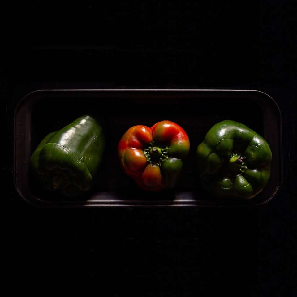 tři oranžové a zelené papriky na černém plátu skládačky online