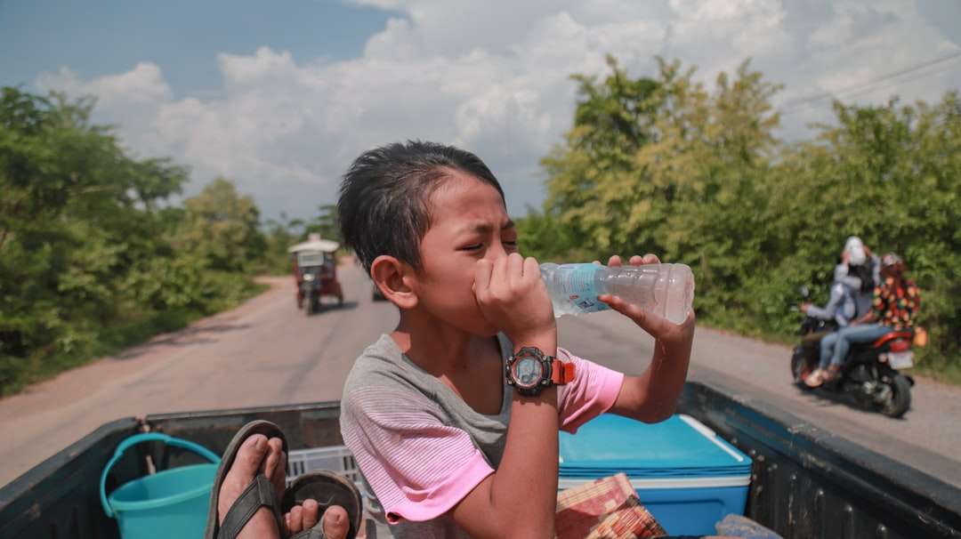 persoon die op gebotteld water drinkt bij pick-up truck legpuzzel online