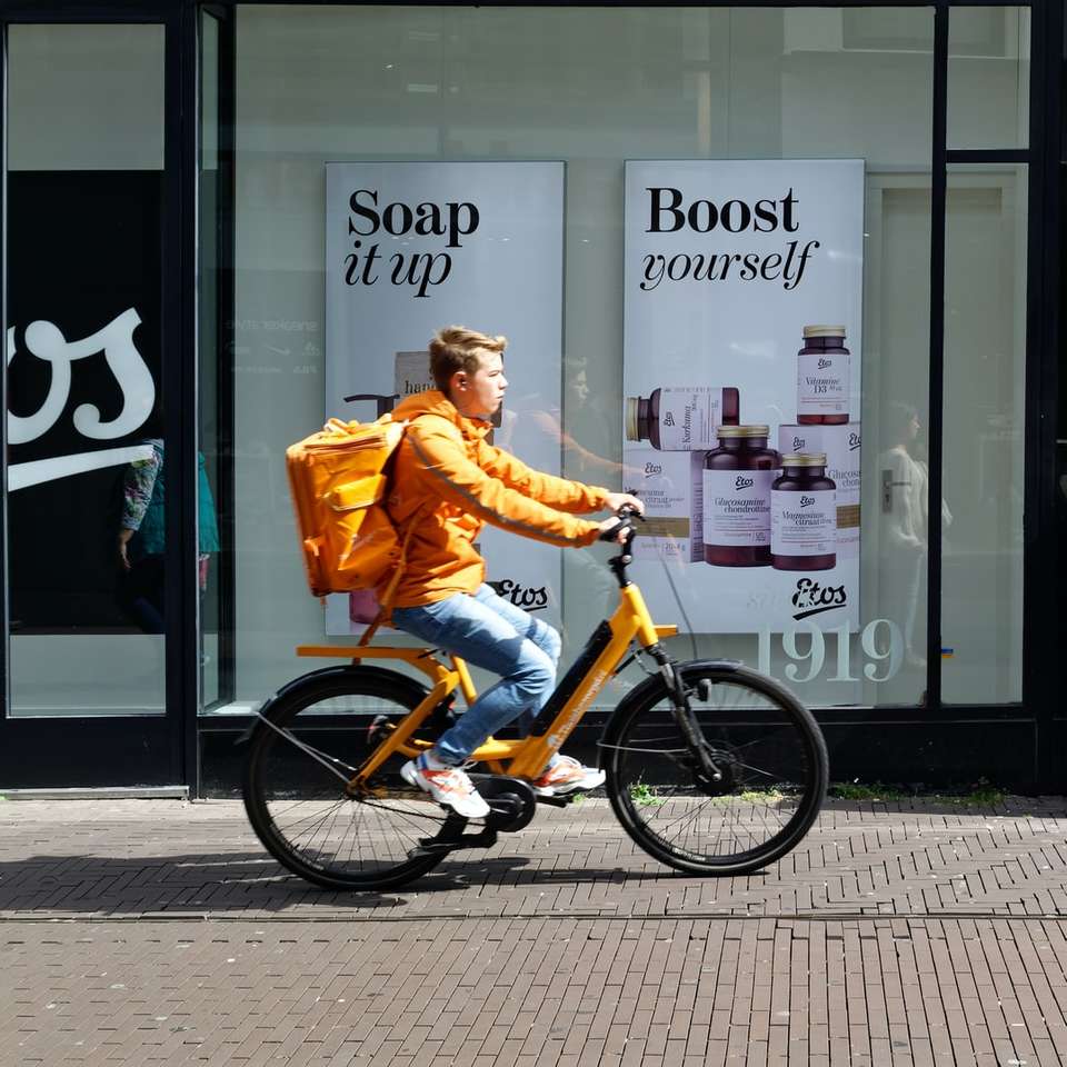 bărbat în jachetă portocalie cu bicicleta pe timpul zilei jigsaw puzzle online