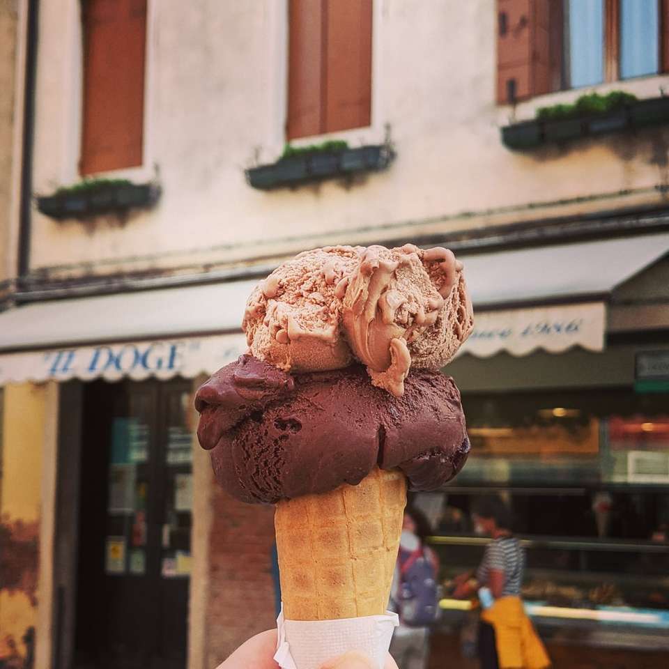 persona sosteniendo un cono de helado marrón rompecabezas en línea
