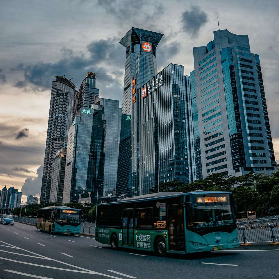 autobuz alb pe drum lângă clădiri înalte în timpul zilei jigsaw puzzle online