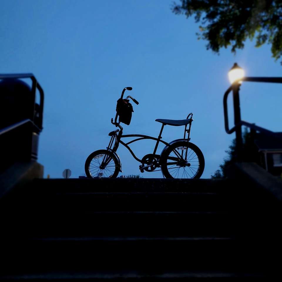 Schattenbild des Mannes, der Fahrrad während des Sonnenuntergangs reitet Online-Puzzle