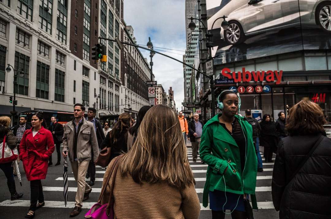 vrouw die groene jas draagt ​​die op de voetgangersbaan loopt legpuzzel online