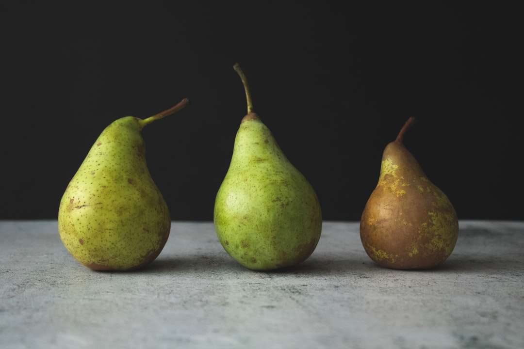 två gröna päronfrukter på vit textil pussel på nätet