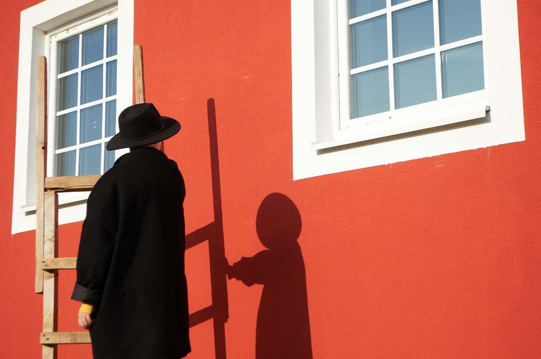 мужчина в черной шляпе стоит у окна онлайн-пазл