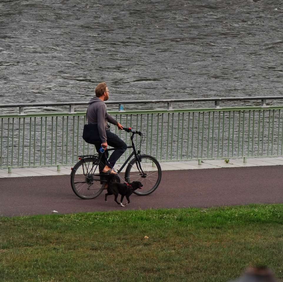 homem de jaqueta marrom andando de bicicleta preta puzzle online
