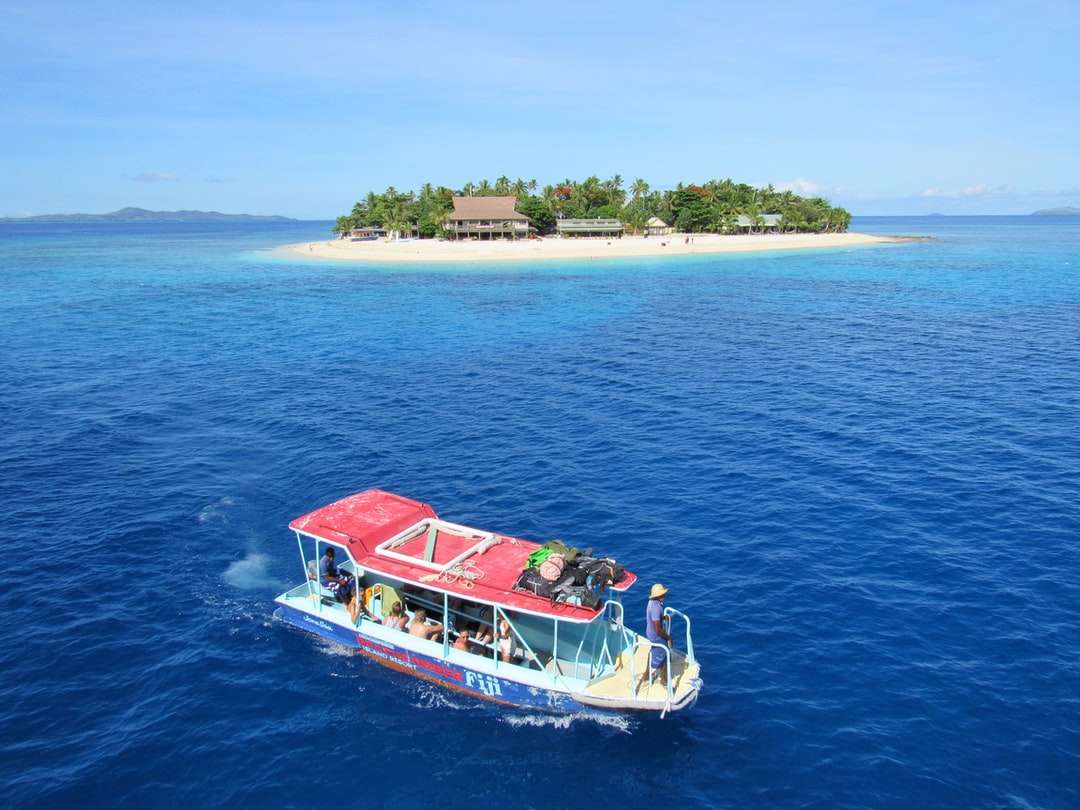 Leute, die Boot auf Gewässern nahe Insel reiten Online-Puzzle