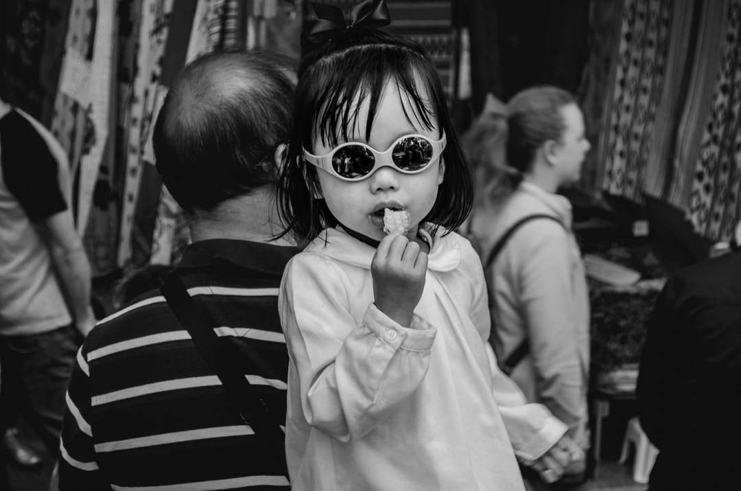 greyscale photo of child eating jigsaw puzzle online