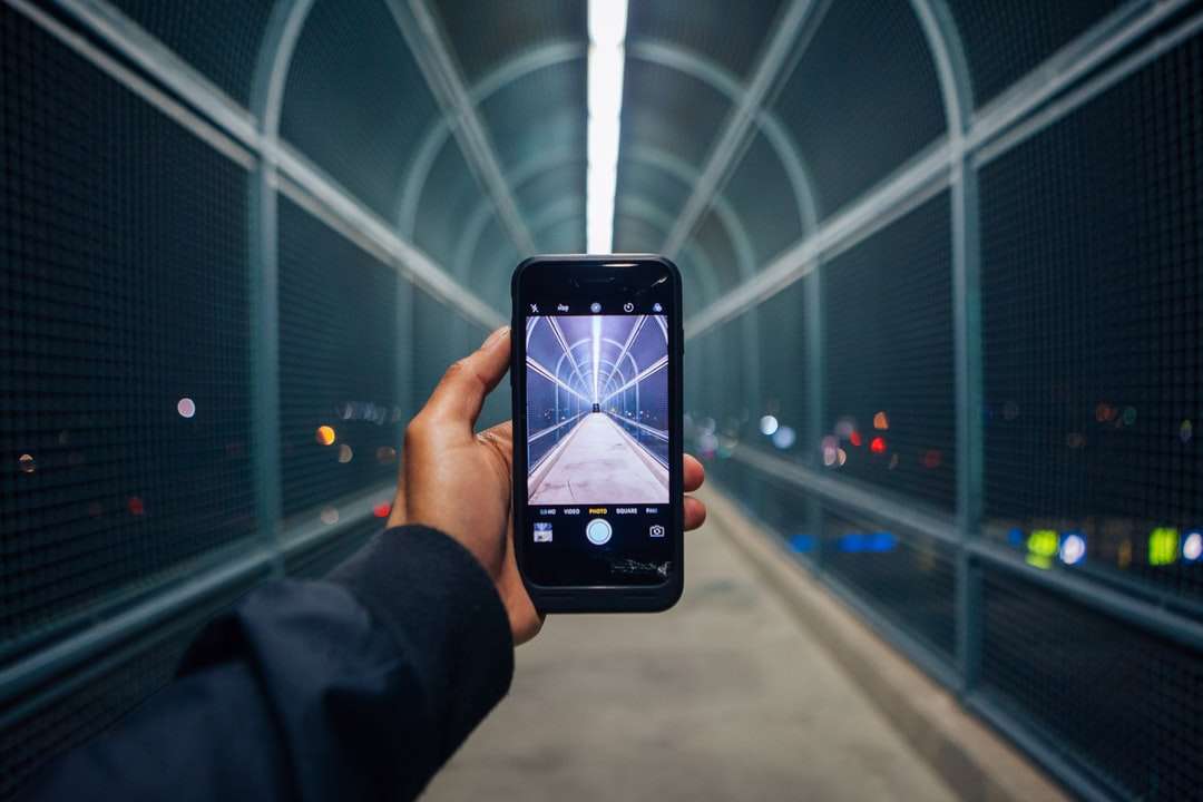 osoba, která drží telefon zobrazující prázdný tunel skládačky online