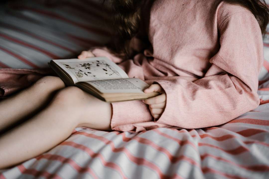 mulher lendo livro em tecido branco e vermelho quebra-cabeças online