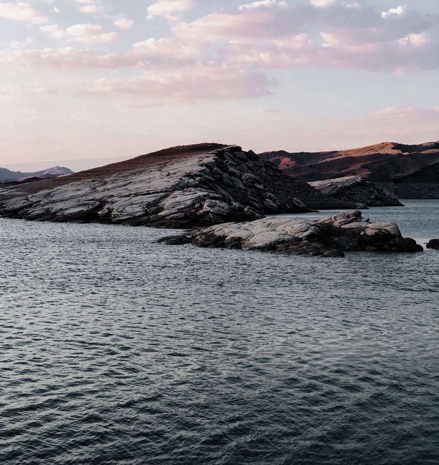 munți maro și negru lângă corpul de apă puzzle online