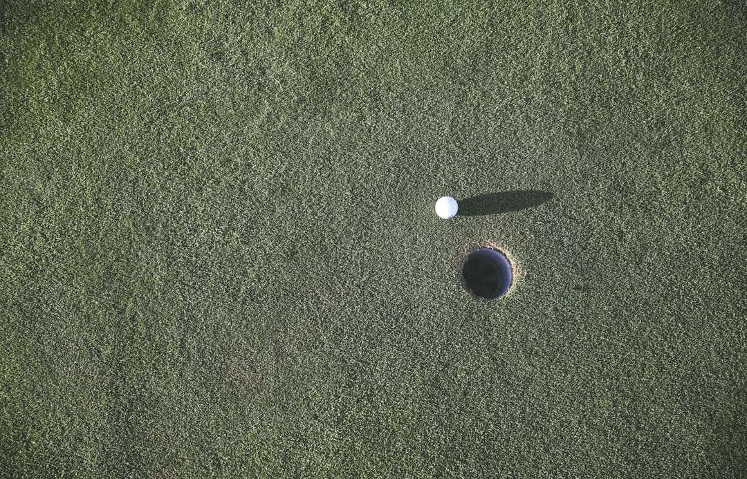 vit golfboll nära hål Pussel online