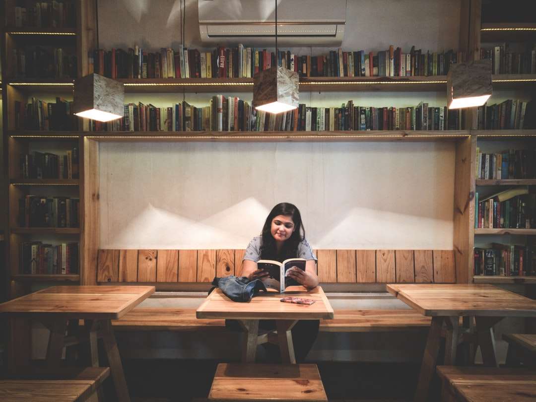 žena čtení knihy uvnitř knihovny online puzzle