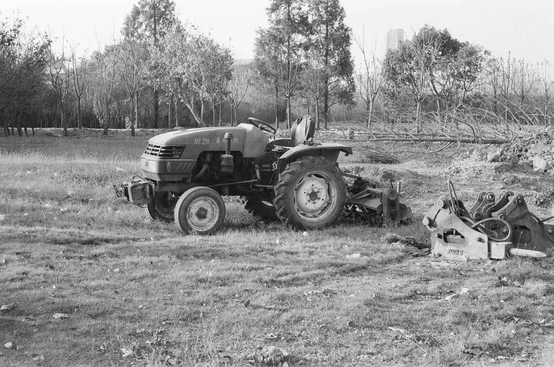 foto in scala di grigi del trattore sul campo in erba puzzle online