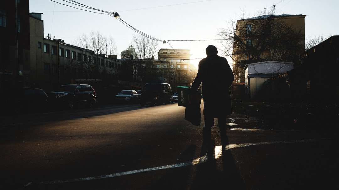 άντρας σε μαύρο σακάκι στέκεται στο δρόμο κατά τη διάρκεια της ημέρας παζλ online