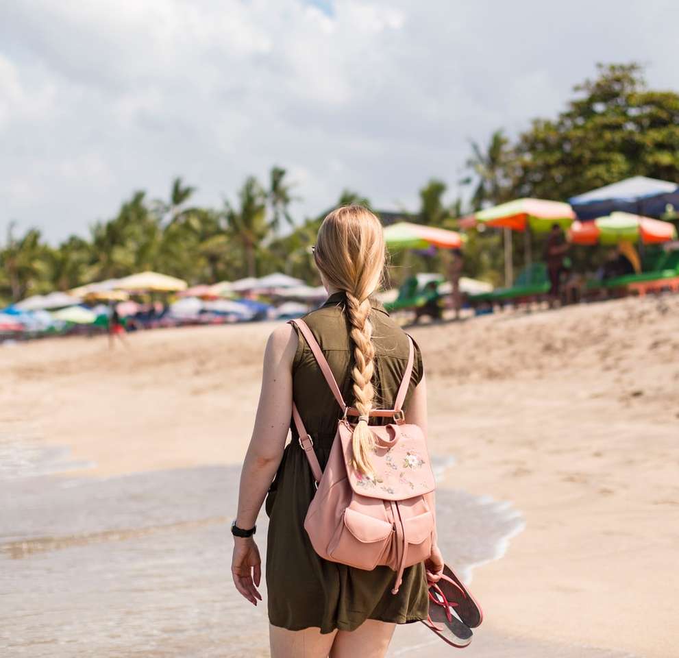 жінка в чорно-коричневій сукні, стоячи на пляжі пазл онлайн
