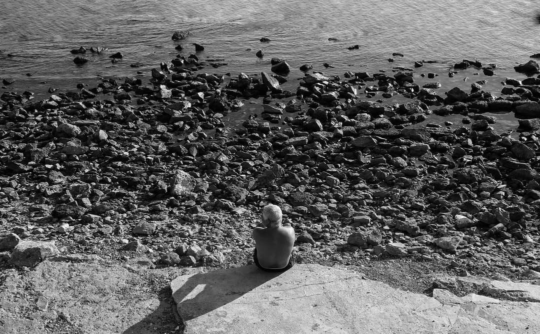 grijswaardenfoto van vrouw zittend op betonnen bankje legpuzzel online