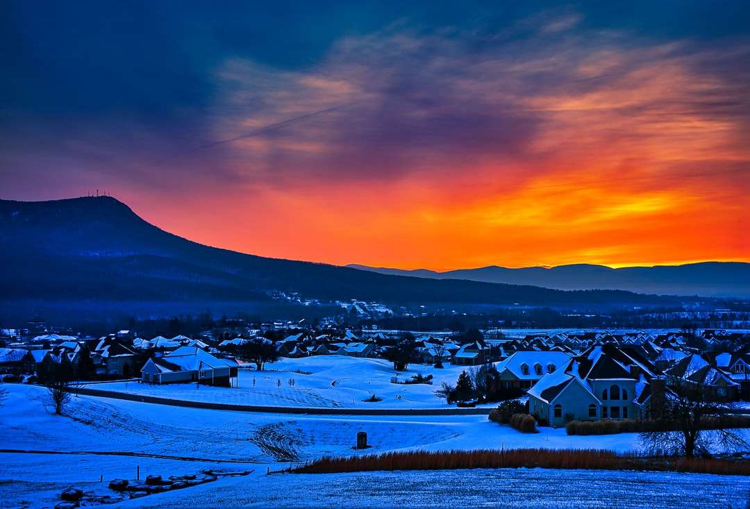 Häuser auf schneebedecktem Boden während des Sonnenuntergangs Puzzlespiel online