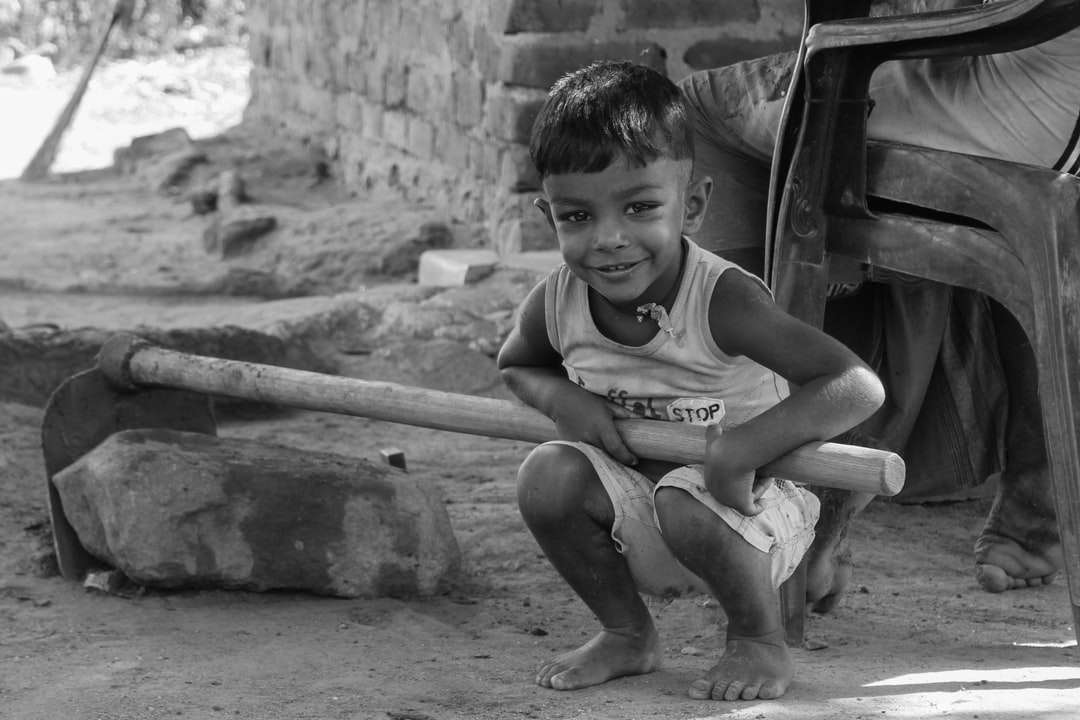 gråskala foto av pojke i linne sitter på betongvägg Pussel online