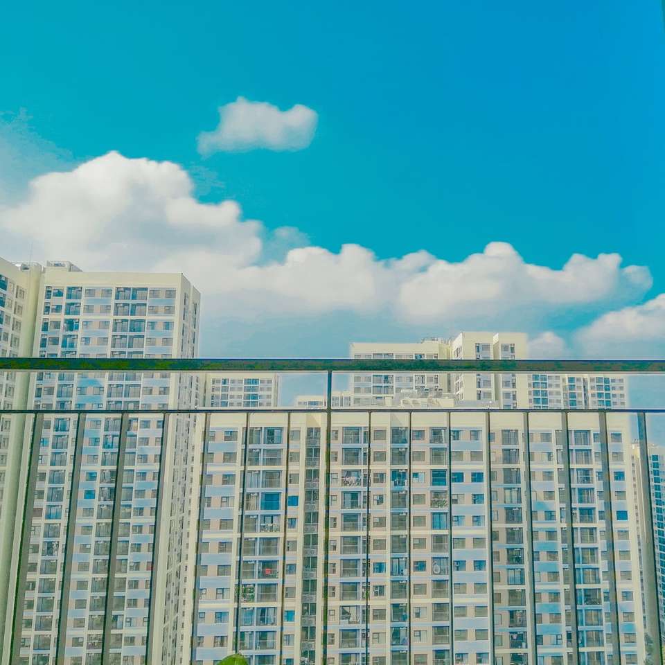 wit en grijs betonnen gebouw onder de blauwe hemel legpuzzel online