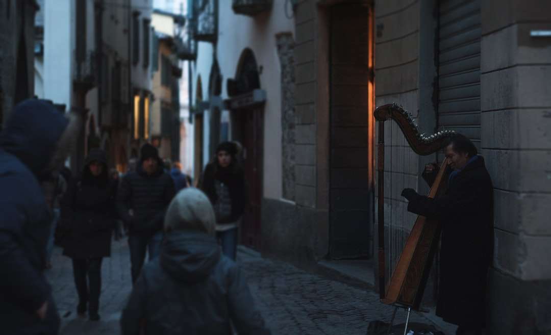 Mann, der Musikinstrument nahe brauner Backsteinmauer spielt Puzzlespiel online
