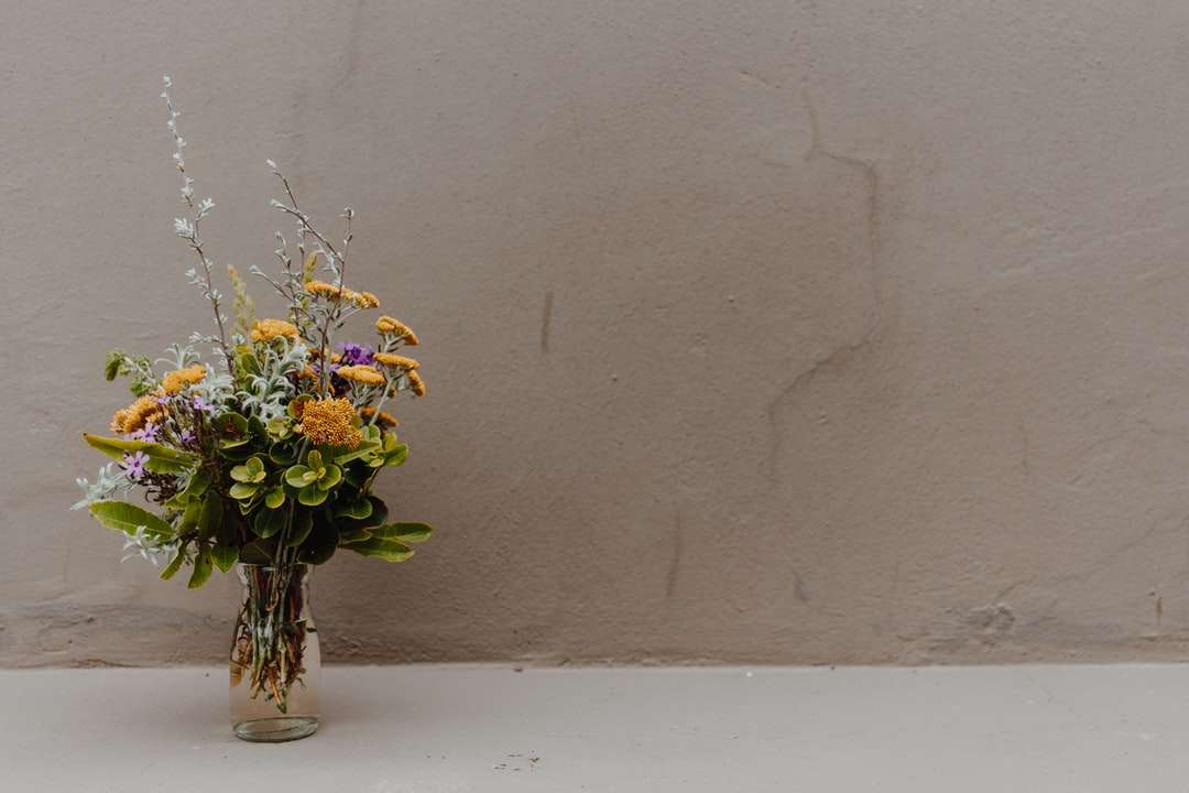 flores amarillas y blancas en jarrón de vidrio transparente rompecabezas en línea