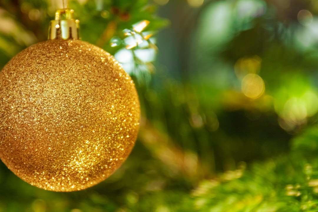 χρυσό στολίδι κρεμασμένο σε πράσινο δέντρο online παζλ