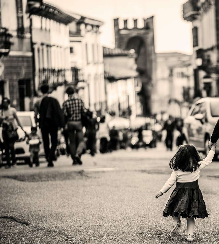 Fotografía en escala de grises de niño caminando sobre pavimento rompecabezas en línea
