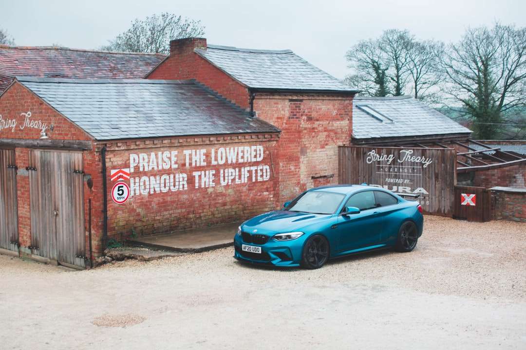 chevrolet camaro azul estacionado ao lado de prédio de tijolos marrons puzzle online