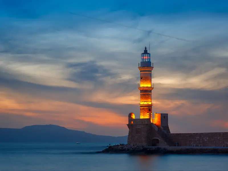 Faro illuminato in riva al mare la sera puzzle online