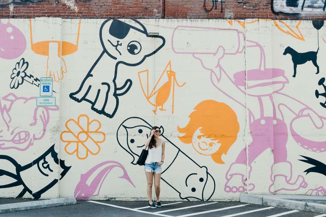 Fotografía sincera de mujer de pie contra la pared de graffiti rompecabezas en línea