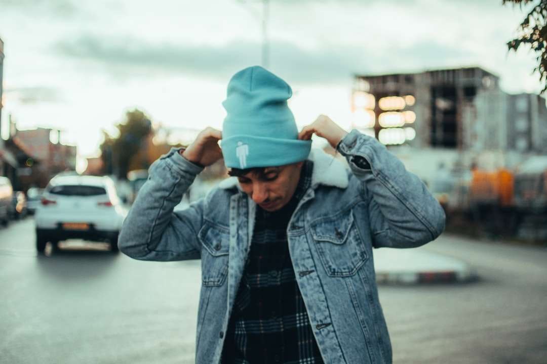 Hombre con chaqueta de mezclilla azul y gorra azul de pie en la carretera rompecabezas en línea