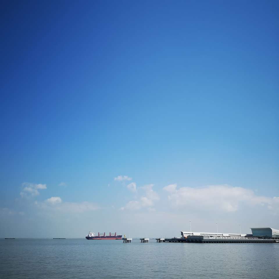 Barco blanco en el mar bajo un cielo azul durante el día rompecabezas en línea