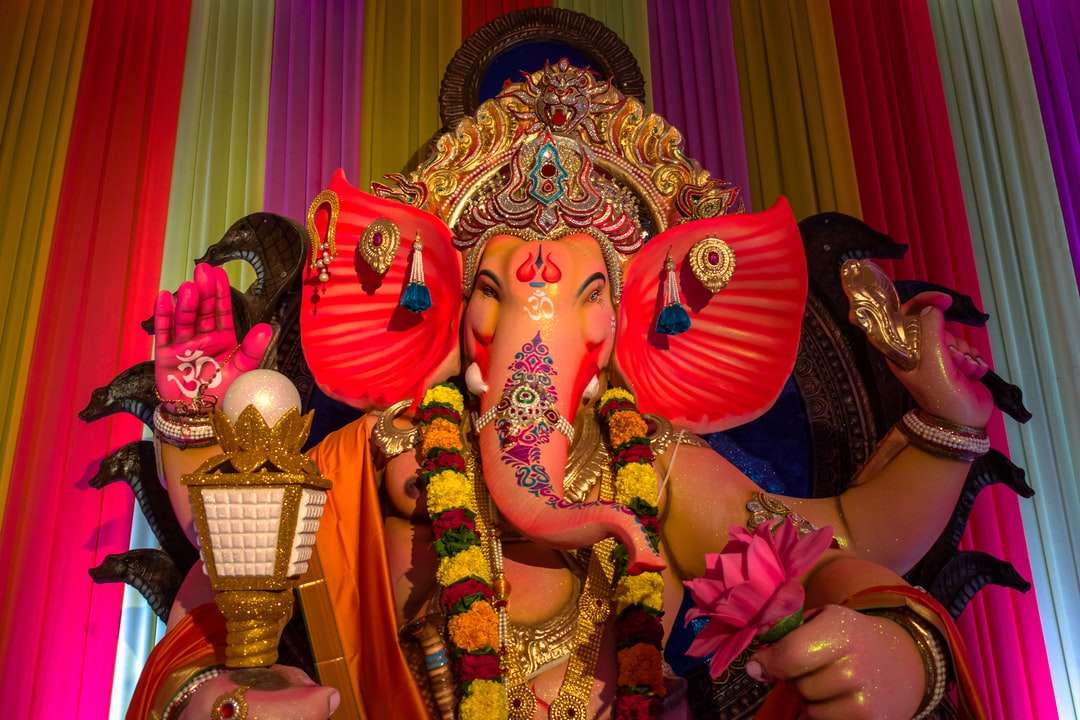 Hindu-Gottheitsstatue vor lila Vorhang Puzzlespiel online