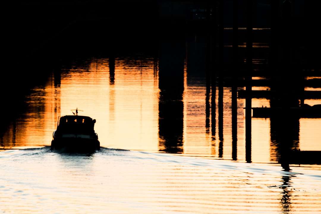 Schattenbild des Bootes auf Wasser während des Sonnenuntergangs Online-Puzzle