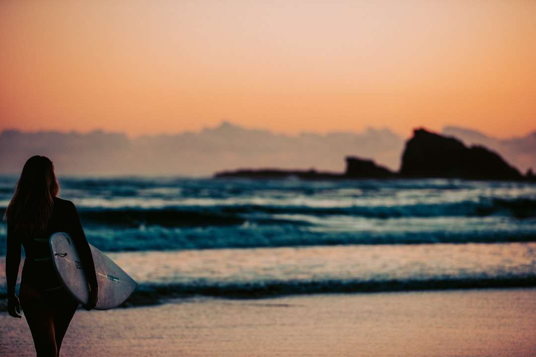 Tente de plage blanche et brune sur la plage pendant le coucher du soleil puzzle en ligne