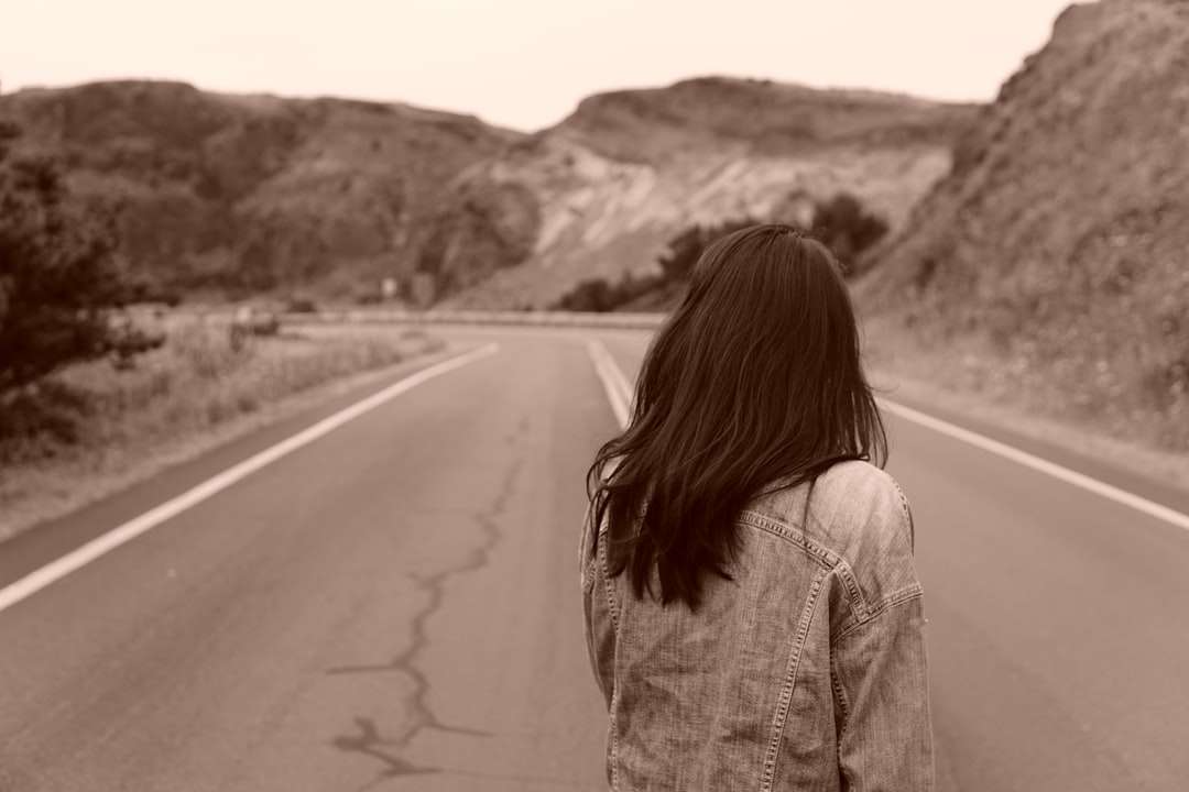 žena v šedé džínové bundě stojící na silnici během dne online puzzle
