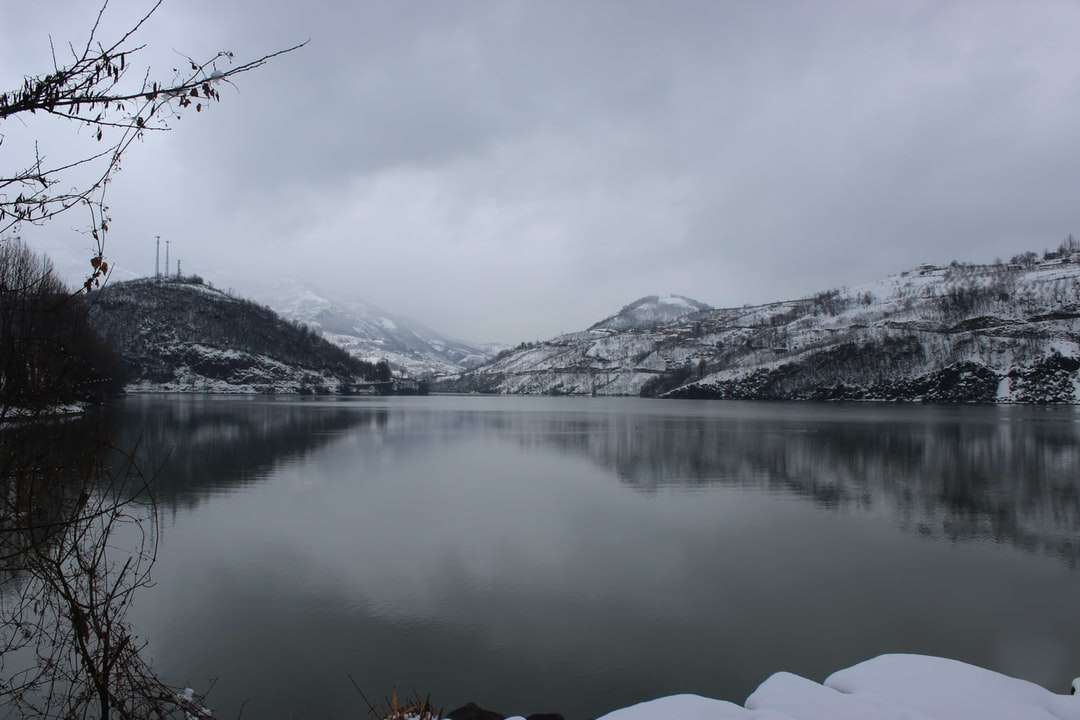 заснежена планина близо до езерото през деня онлайн пъзел