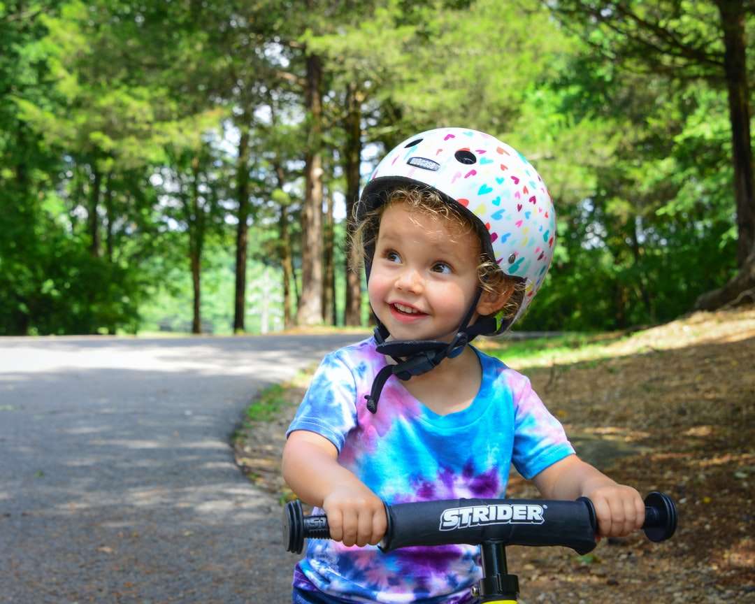 момиче в розов и бял шлем каране на велосипед по пътя онлайн пъзел