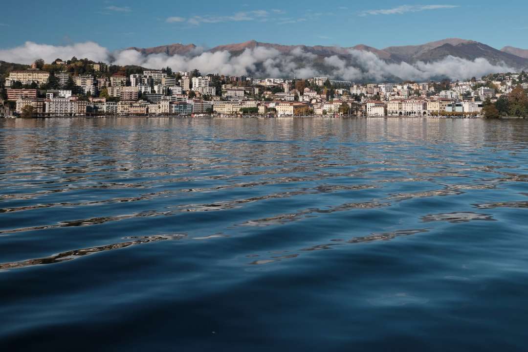 corpo d'água perto de edifícios da cidade sob céu nublado quebra-cabeças online